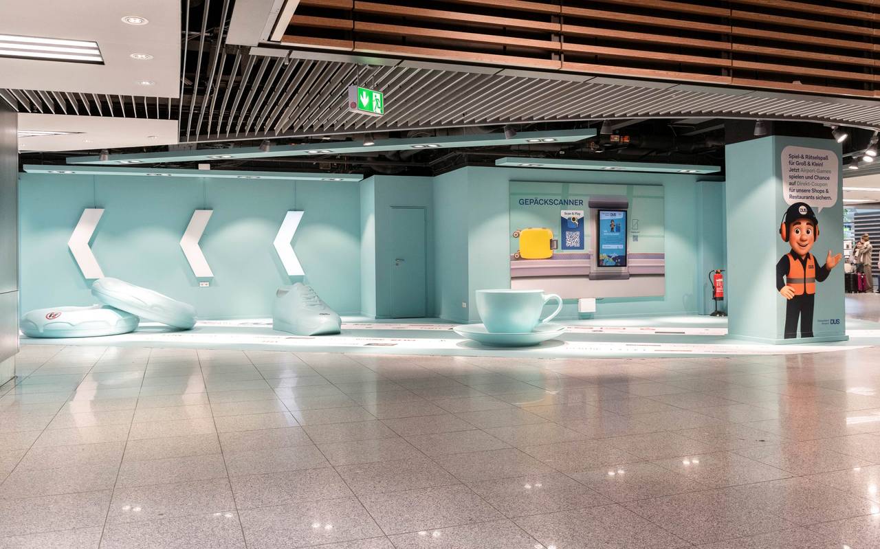 Ein Bereich am Flughafen an dem Besucher Selfies machen und Spiele spielen können. Unter anderem sind übergroße Turnschuhe und eine Kaffeetasse zu sehen.