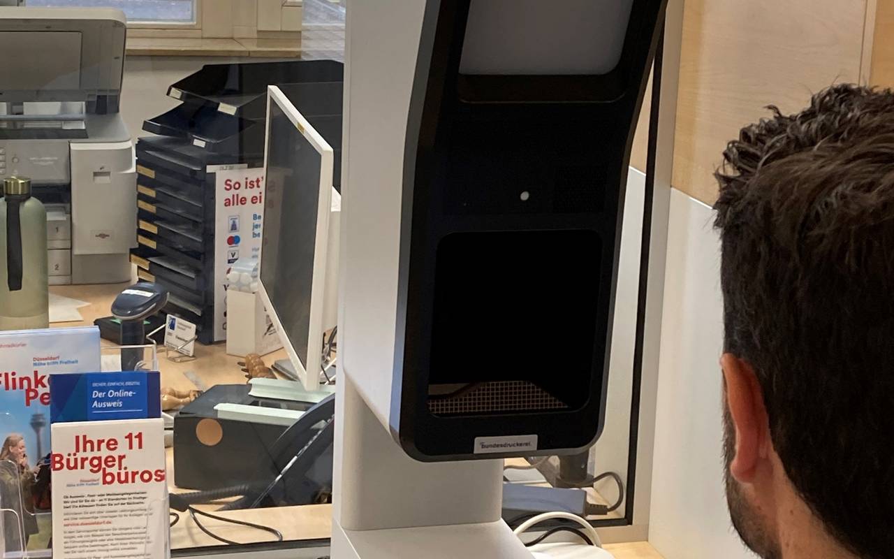 Auf einem Schreibtisch in einem Düsseldorfer Bürgerbüro steht ein Foto-Terminal. Hier können wir digitale Passbilder machen lassen.