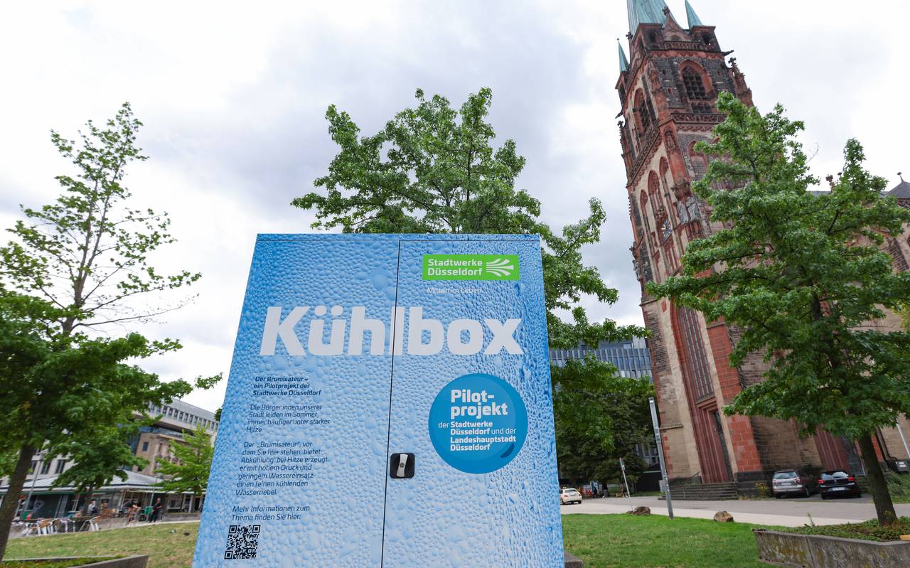 Eine große Kühlbox, genannt Brumisateur, steht auf dem Kirchplatz - ein Pilotprojekt zur Stadtabkühlung von Stadt und Stadtwerke.