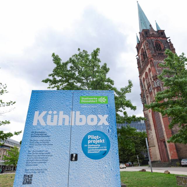 Eine große Kühlbox, genannt Brumisateur, steht auf dem Kirchplatz - ein Pilotprojekt zur Stadtabkühlung von Stadt und Stadtwerke.