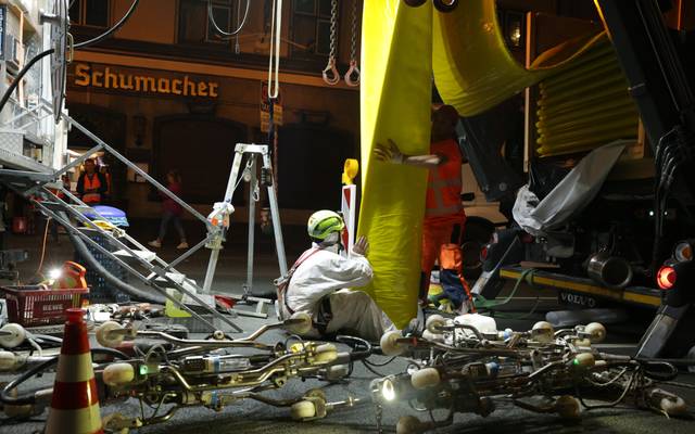 Der Stadtentwässerungsbetrieb hat den Kanal an der Oststraße saniert. Hier ist der Einzug des "Inliners" zu sehen. Zwei Männer in weißen und orangenen Schutzjacken führen den gelben Schlauch in den Kanal ein.