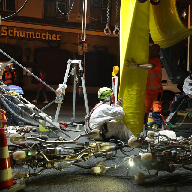 Der Stadtentwässerungsbetrieb hat den Kanal an der Oststraße saniert. Hier ist der Einzug des "Inliners" zu sehen. Zwei Männer in weißen und orangenen Schutzjacken führen den gelben Schlauch in den Kanal ein.