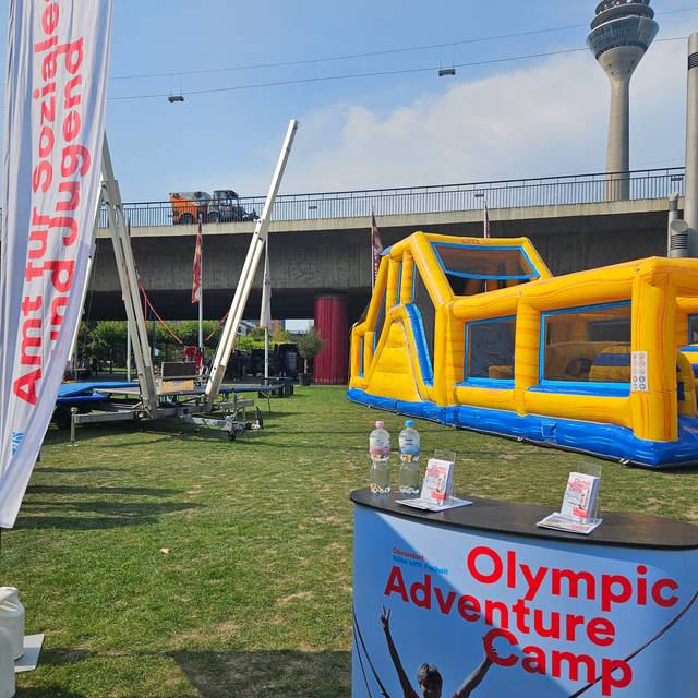 Olympic adventure Camp mit Hüpfburg und Aussicht auf den Rheinturm.