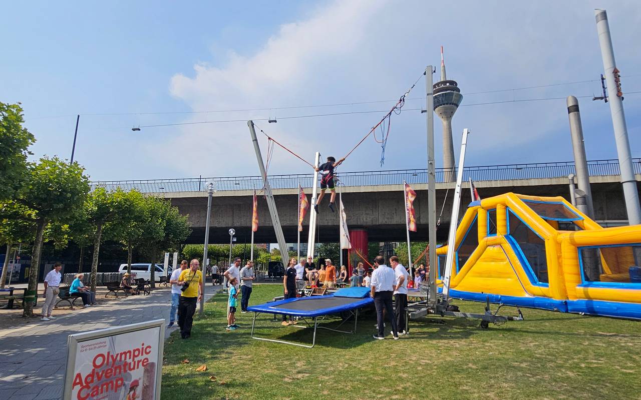 Olympic adventure Camp mit Hüpfburg, Trampolin und Aussicht auf den Rheinturm.