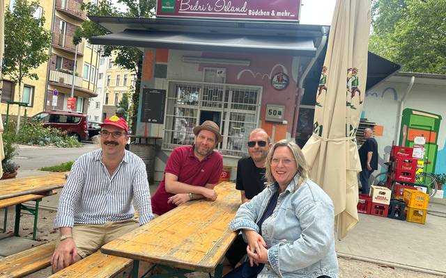 Der Vorstand des Büdchentags auf einer Bank vor Bedris Island Büdchen und mehr.