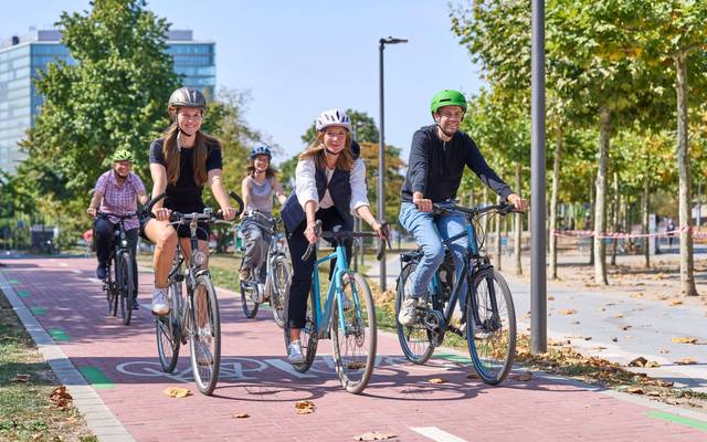 Aufruf zum Mitmachen beim Stadtradeln: Die Landeshauptstadt Düsseldorf beteiligt sich zum zwölften Mal hintereinander am Wettbewerb Stadtradeln des Klima-Bündnisses, dem größten kommunalen Netzwerk für Klimaschutz. Mehrere Fahrradfahrer radeln glücklich über einen Fahrradweg.