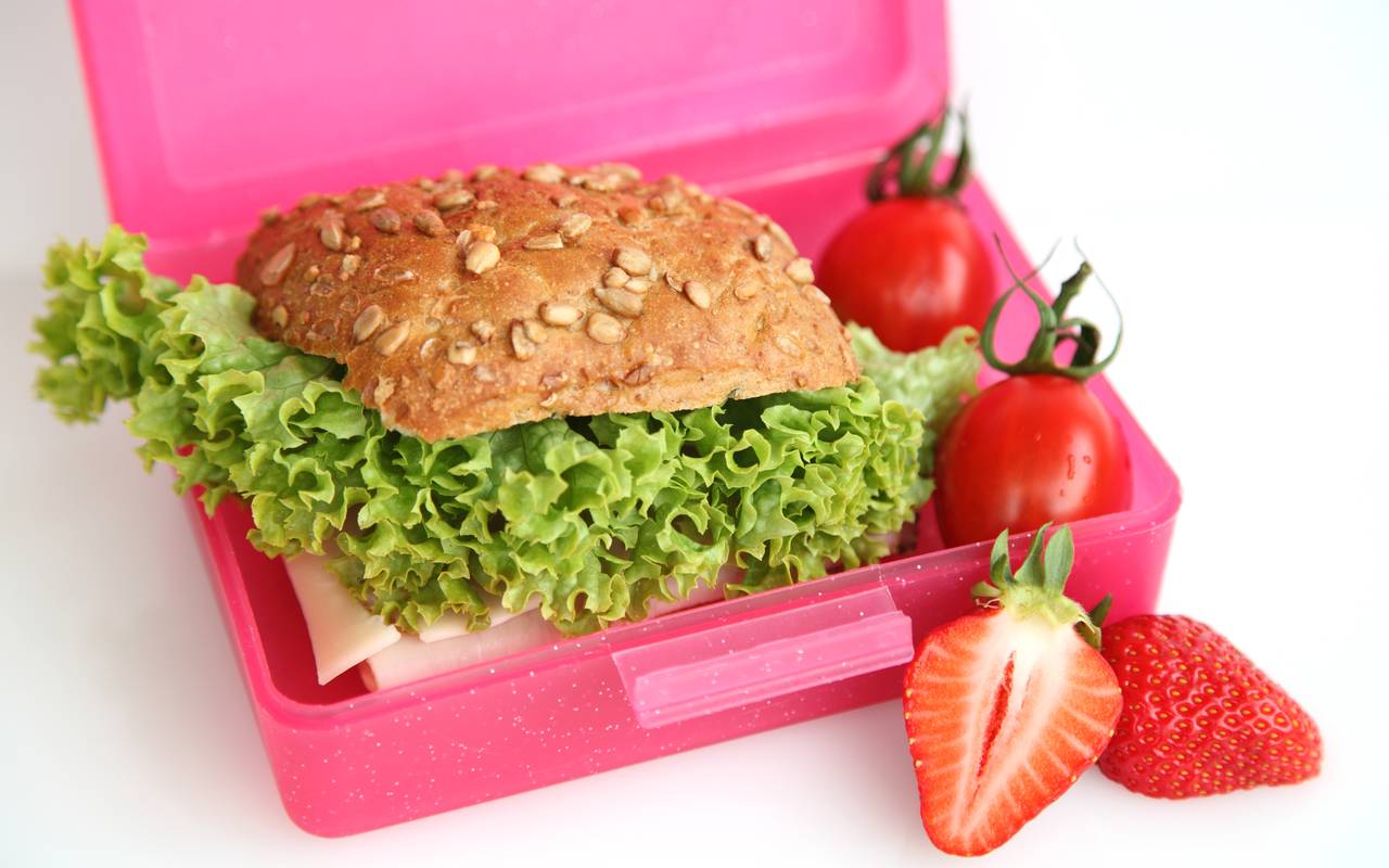 Schulfrühstück in einer Brotbox. Mit Obst, Brötchen und Gemüse.