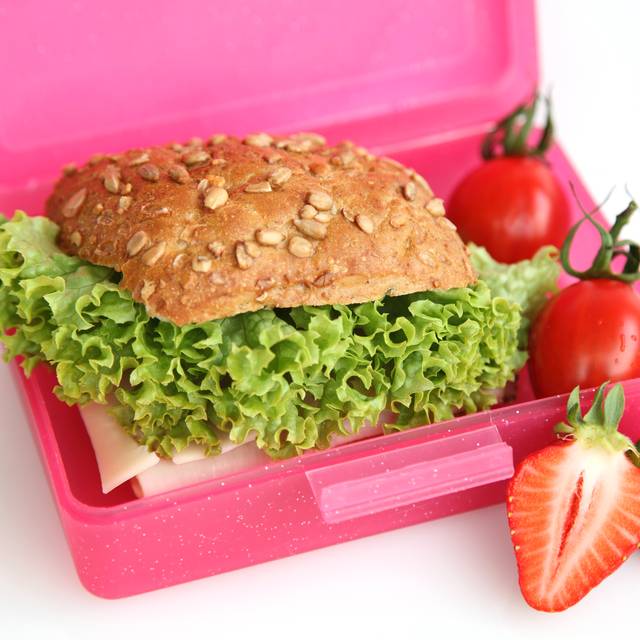 Schulfrühstück in einer Brotbox. Mit Obst, Brötchen und Gemüse.