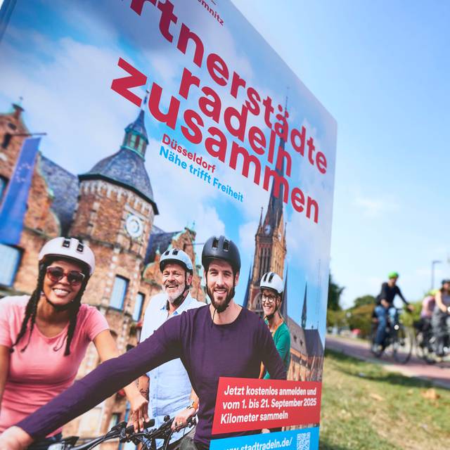 Ein Werbebanner weist auf den Wettbewerb Stadtradeln hin. Im Hintergrund der Rheinturm.