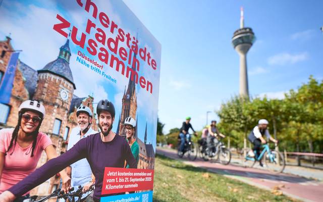 Ein Werbebanner weist auf den Wettbewerb Stadtradeln hin. Im Hintergrund der Rheinturm.