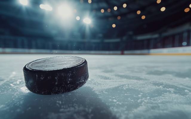 Ein Eishockey-Puck fliegt über das Eis.