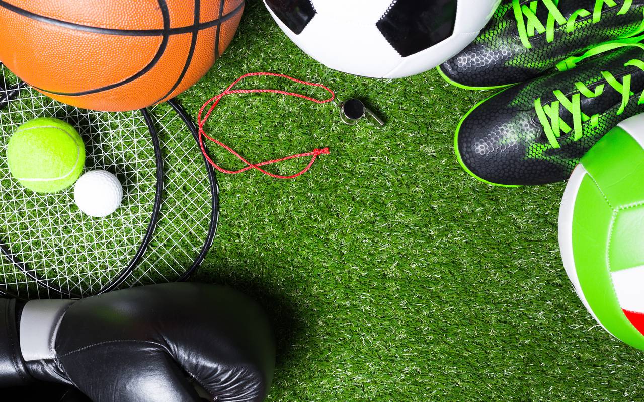 Verschiedene Sportgeräte auf Gras.