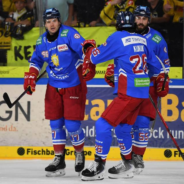 DEG-Spieler in blauen Auswärtstrikots bejubeln ein Tor beim Spiel bei den Krefelder Pinguinen.