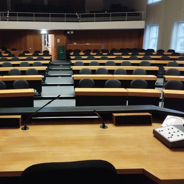 Blick in den leeren Ratssaal im Düsseldorfer Rathaus. Auf dem Tisch des OB stehen Laptop, Mikrofon und eine alte Uhr.