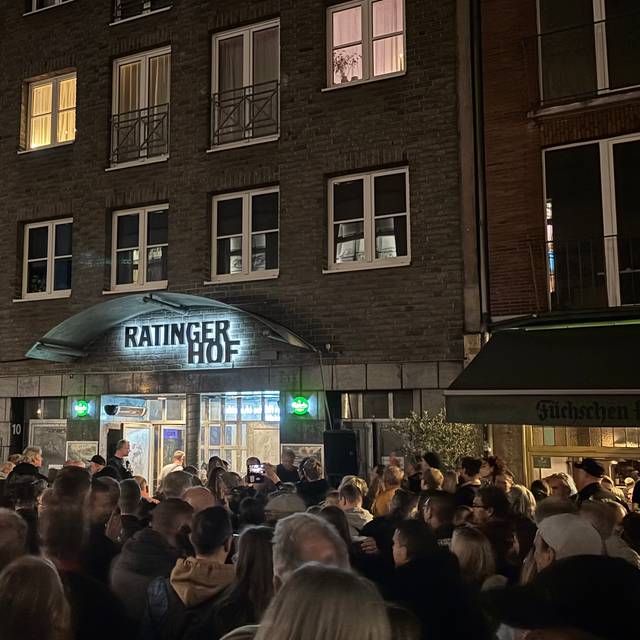 Fans der Toten Hosen verfolgen auf der Ratinger Straße per Lautsprecher ein Konzert der Toten Hosen im Ratinger Hof.
