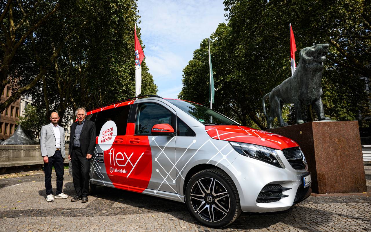 Christian Finke, Bereichsleiter Betrieb der Rheinbahn und Mobilitäts- und Umweltdezernent Jochen Kral stehen vor einem grauen Flexy-Fahrzeug.