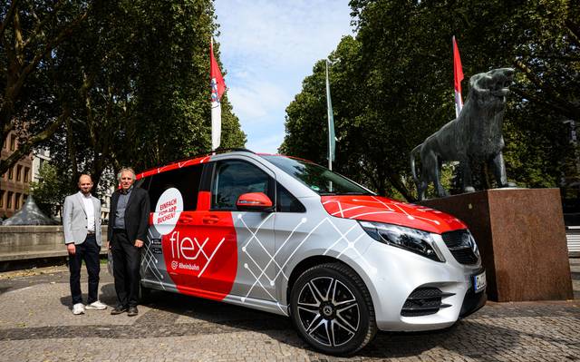 Christian Finke, Bereichsleiter Betrieb der Rheinbahn und Mobilitäts- und Umweltdezernent Jochen Kral stehen vor einem grauen Flexy-Fahrzeug.