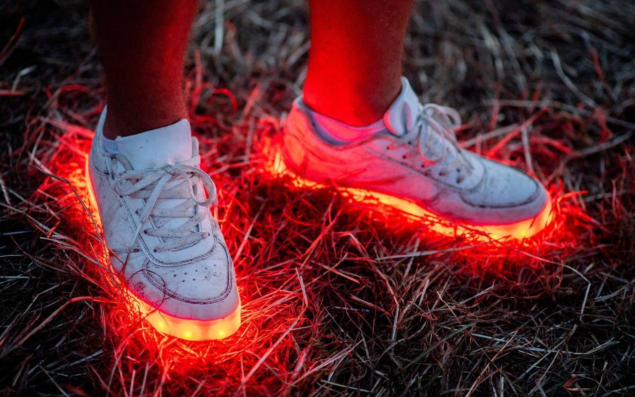Ein Mann trägt ein paar rotleuchtende Schuhe