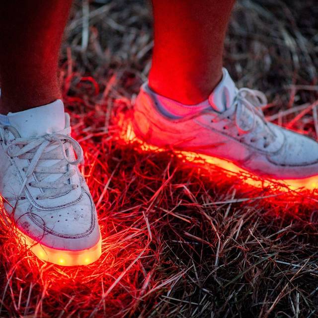 Ein Mann trägt ein paar rotleuchtende Schuhe