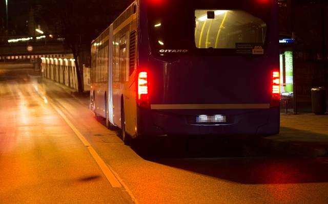 Ein Bus fährt nachts auf eine Unterführung zu