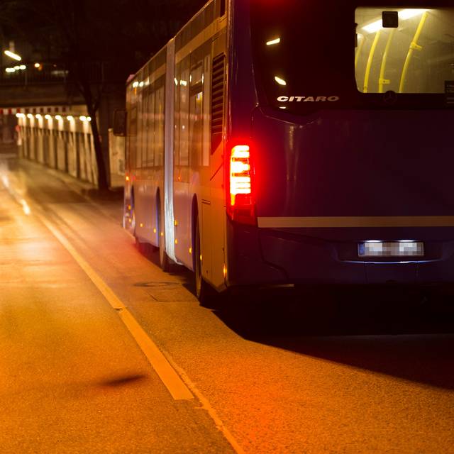 Ein Bus fährt nachts auf eine Unterführung zu