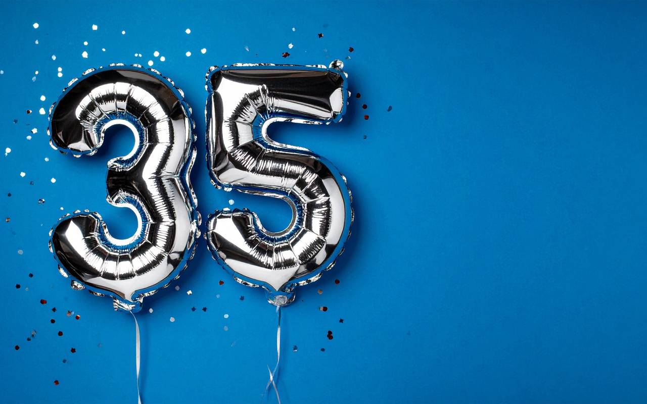 Banner mit zwei Ballons in Form der Zahl 35 vor einem dunkelblauen Hintergrund.