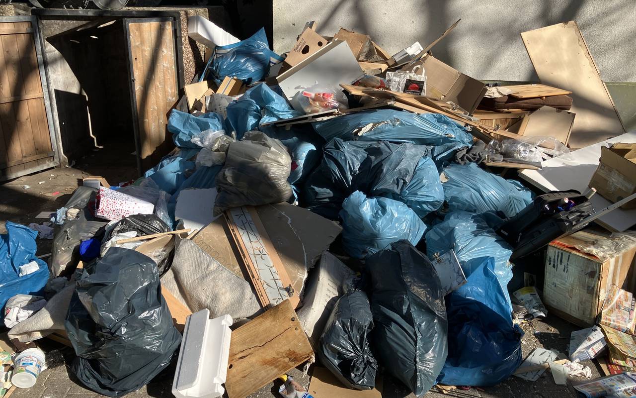 Mehrere Säcke mit Bauschutt liegen in Hassels auf dem Bürgersteig neben anderen abgelagerten Abfällen. Darunter sind Pappkartons, alte Möbel und anderer Müll.