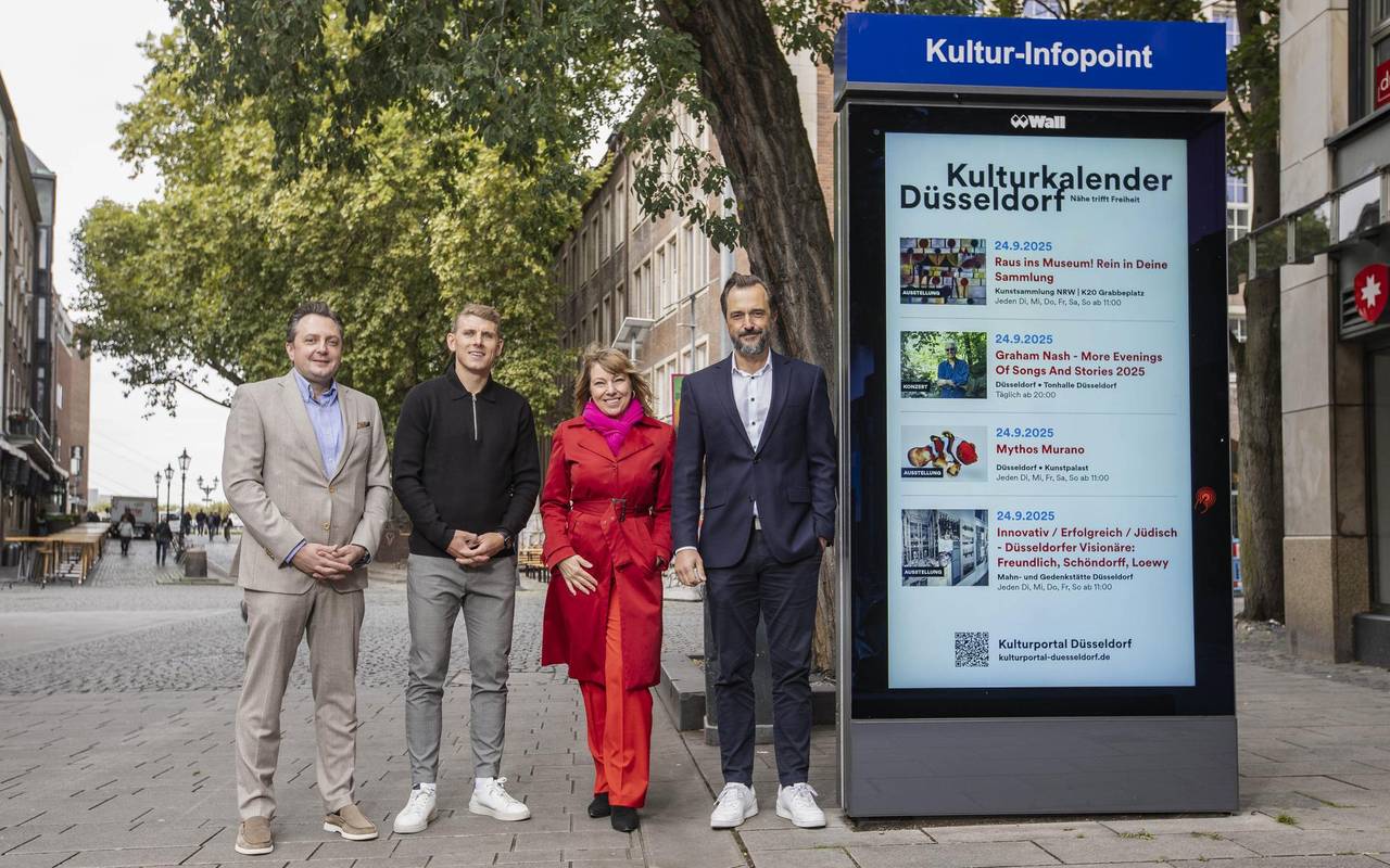 Vertretende von der Stadt neben der neuen Kultur-Infotafel auf der Bolkerstraße.