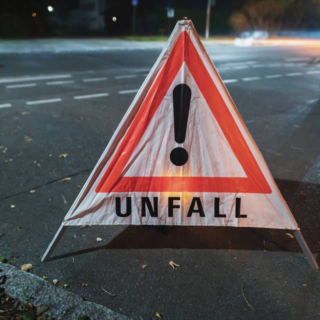 Warndreieck mit der Aufschrift Unfall bei einem nächtlichen Einsatz.