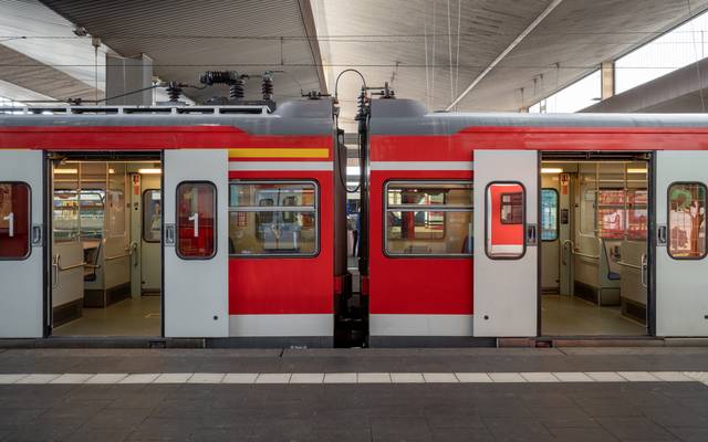 Eine S-Bahn hält am Bahnsteig eines Bahnhofs in Düsseldorf, Deutschland, und die automatischen Türen öffnen sich.