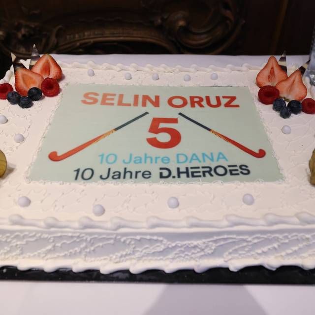 Große Torte für die Düsseldorfer Hockeyspielerin Selin Oruz. Darauf sind auch ihre Nummer 5 und zwei Hockeyschläger zu sehen. Außerdem ist die Torte an den Ecken mit Früchten garniert.