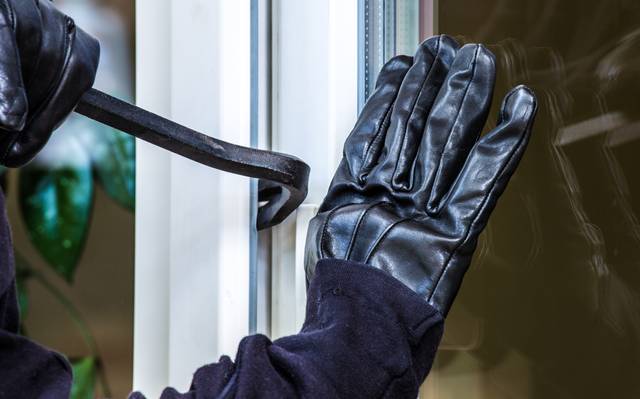 Ein unbekannter Einbrecher hebelt eine Terrassentür auf.