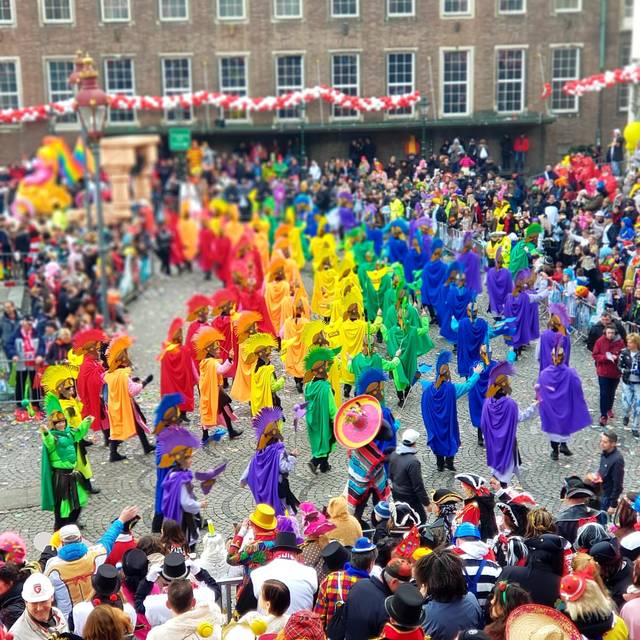 Die KG Regenbogen zieht beim Rosenmontagszug in bunten Kostümen über den Marktplatz.