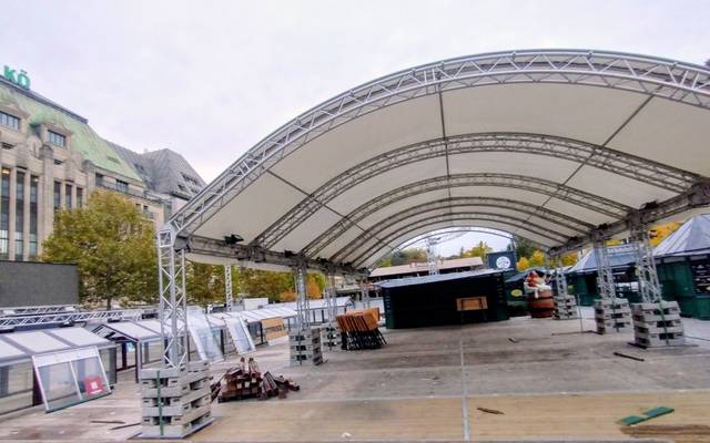 Aufbau der Eisbahn am Corneliusplatz auf der Kö. Neben dem Kaufhof erkennen wir unter anderem den Boden der späteren Eisbahn und das Zeltdach.