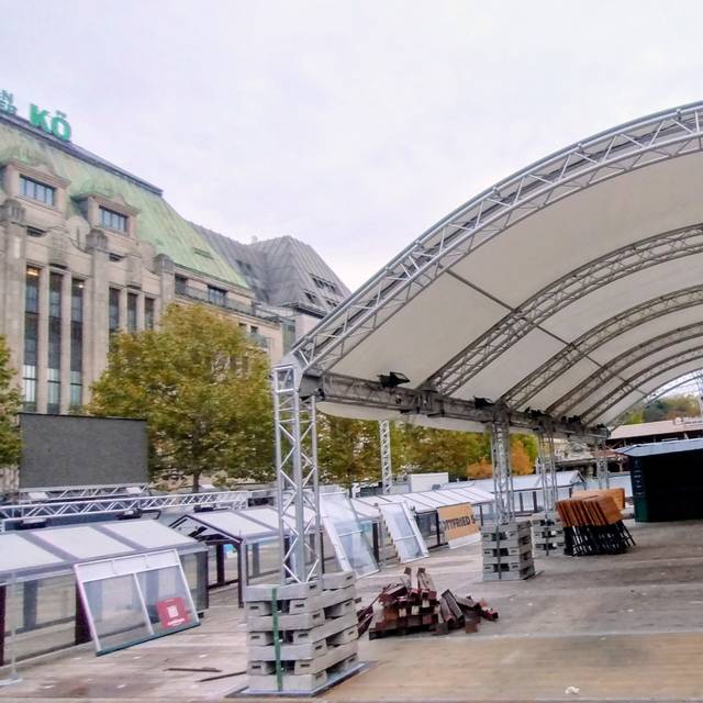 Aufbau der Eisbahn am Corneliusplatz auf der Kö. Neben dem Kaufhof erkennen wir unter anderem den Boden der späteren Eisbahn und das Zeltdach.
