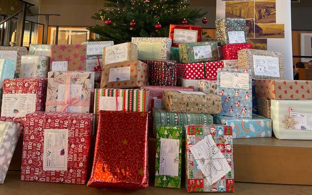 Geschenke für das Project Nadiya vor dem Weihnachtsbaum in der Marie-Curie-Schule