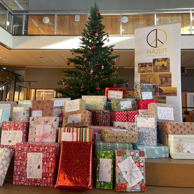 Geschenke für das Project Nadiya vor dem Weihnachtsbaum in der Marie-Curie-Schule