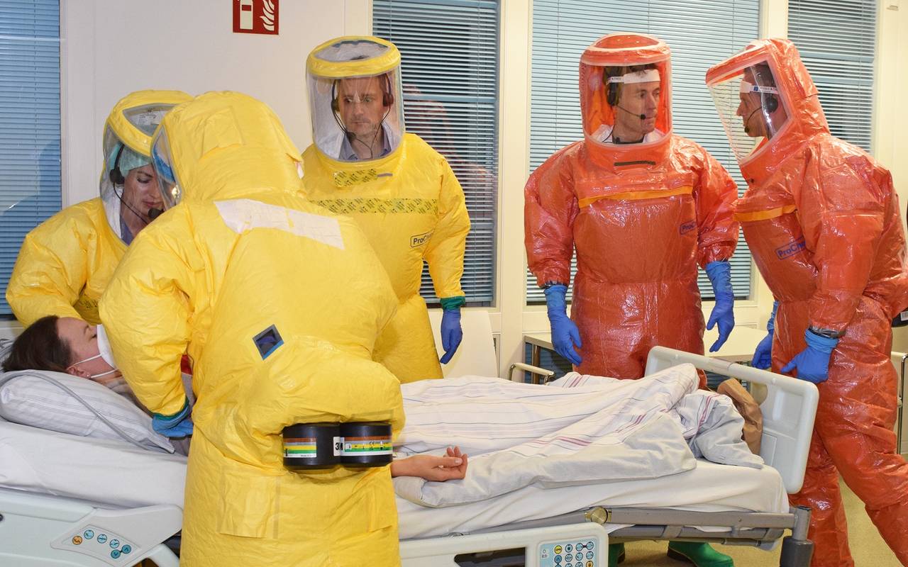 Retter in gelben und orangenen Schutzanzügen versorgen eine Patientin im Rahmen einer Hochinfektions-Übung.