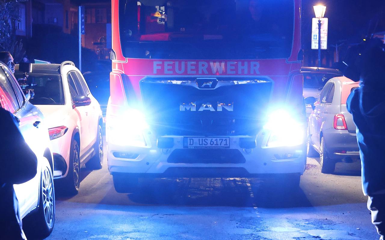 Ein Wagen der Feuerwehr hat Schwierigkeiten, durch eine eng geparkte Straße zu kommen.