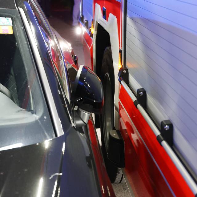 Ein Feuerwehrauto fährt nur mit knapper Not an einem geparkten Auto vorbei. Die Szene verdeutlicht, wie falsch oder eng geparkte Fahrzeuge Rettungskräften den Weg versperren und dadurch im Einsatz wertvolle Zeit verloren geht.