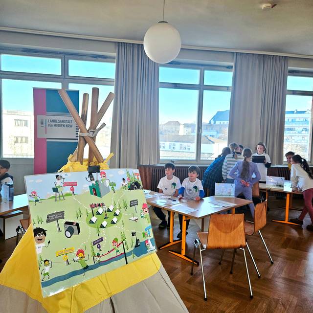 Kinder nehmen in der Aula der Bonifatius Grundschule am Programm der Medienscouts teil.