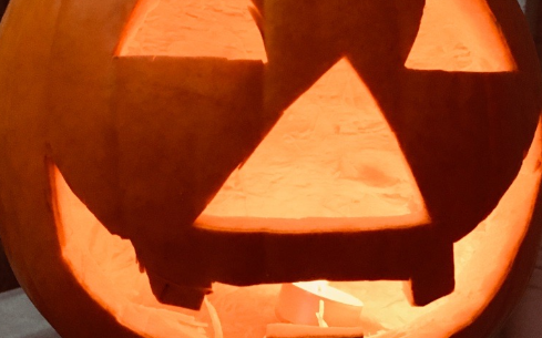 Ein Kürbis mit einer geschnitzten und beleuchteten Grimasse.