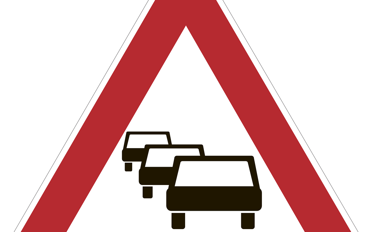 Stau: Ein rotes Dreieck umrandet drei schwarze gezeichnete Autos, die hintereinander im Stau stehen.