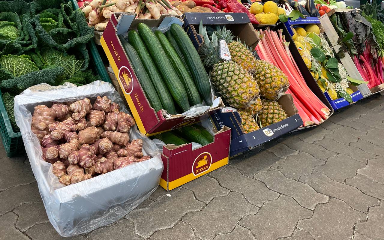 Verschiedene Obst- Gemüsekisten auf dem Großmarkt-Gelände. Unter anderem sind Gurken oder auch Äpfel zu sehen.