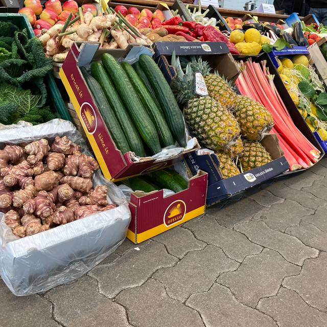 Verschiedene Obst- Gemüsekisten auf dem Großmarkt-Gelände. Unter anderem sind Gurken oder auch Äpfel zu sehen.