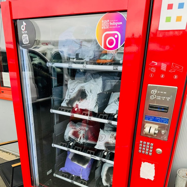 Ein roter Secret-Pack-Automat. Er ist mit Paketen gefüllt.