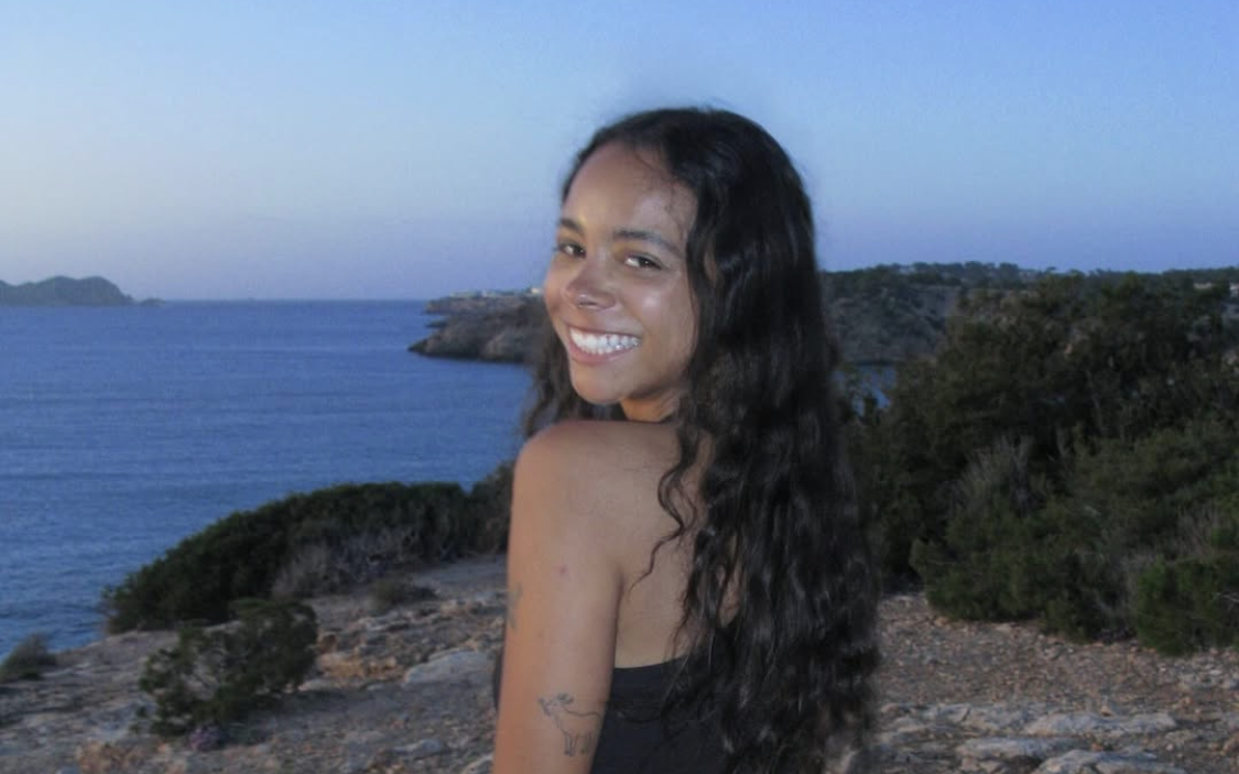 Die britische DJ und Musikproduzentin TSHA im Sommeroutfit am Meer auf Ibiza