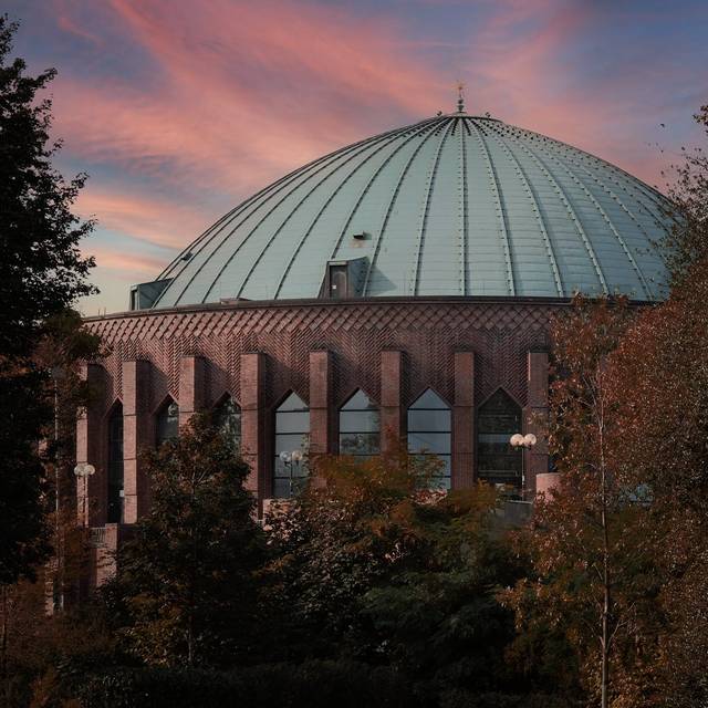 Außenansicht der Düsseldorfer Tonhalle. Der Sonnenuntergang sorgt für schöne Farben im Hintergrund.