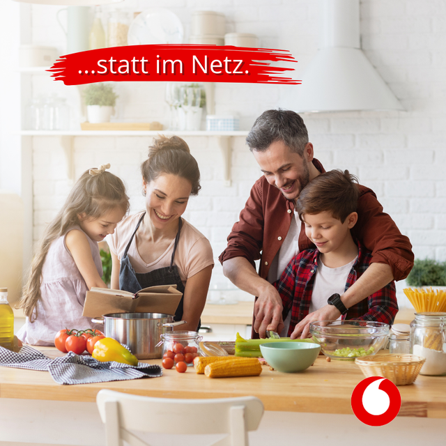 Familie (Eltern mit zwei Kindern) kochen gemeinsam in der Küche.