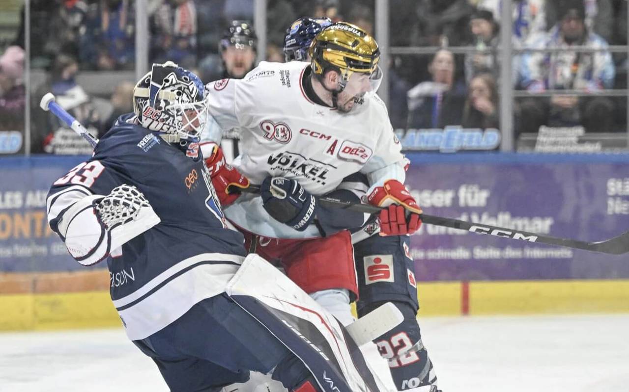 Ein Spieler der Düsseldorfer EG wird von einem Gegenspieler und dem gegnerischen Torwart in die Zange genommen.